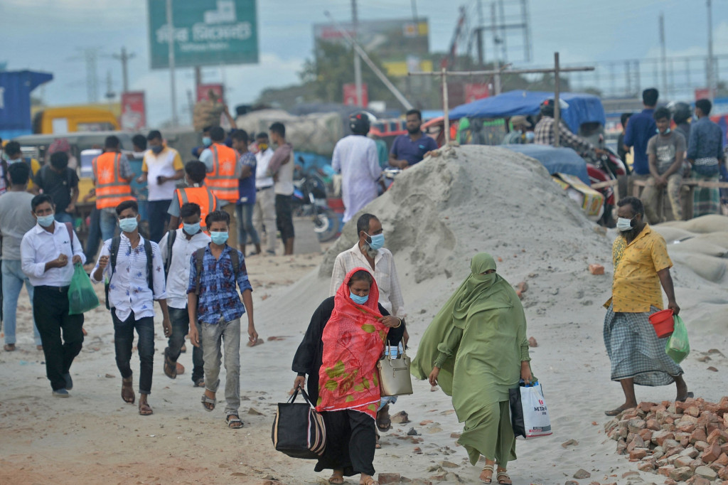 Orang-orang berjalan untuk naik feri menuju kota asal mereka setelah pelonggaran lockdown nasional Covid-19 di Sreenagar.