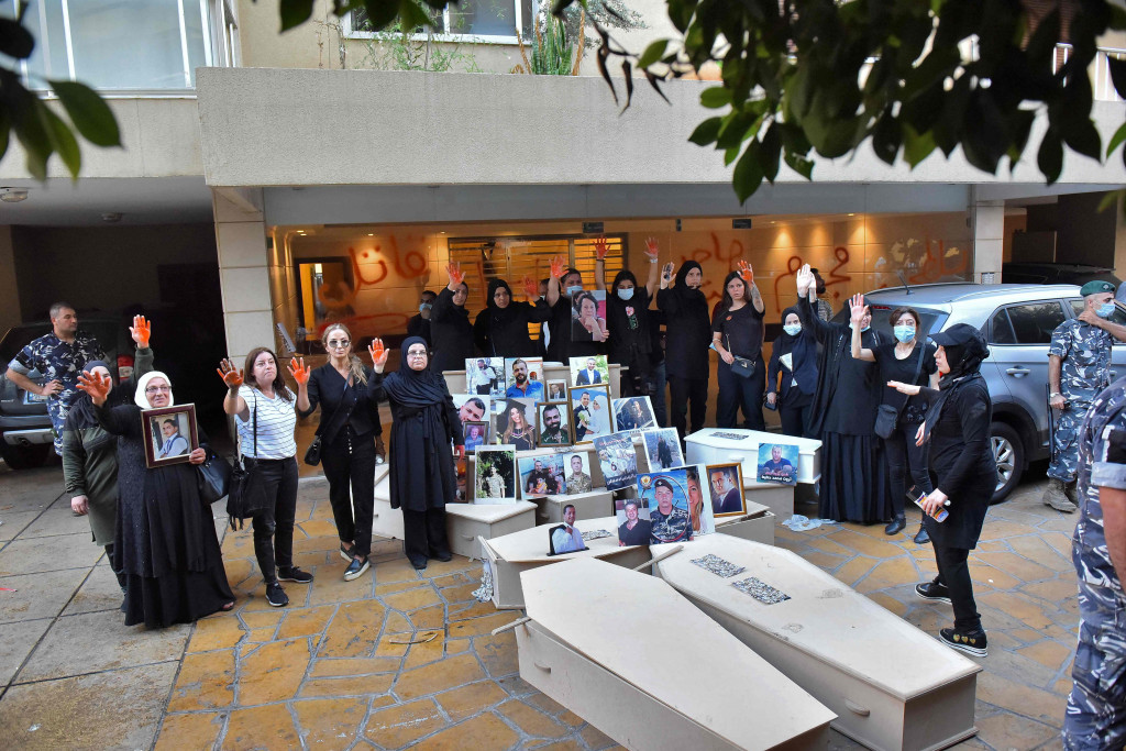 Demonstran dan keluarga korban ledakan Beirut berkumpul dengan peti mati kosong untuk protes di luar kediaman Menteri Dalam Negeri Lebanon di lingkungan Qoraitem di Beirut barat pada 13 Juli 2021.