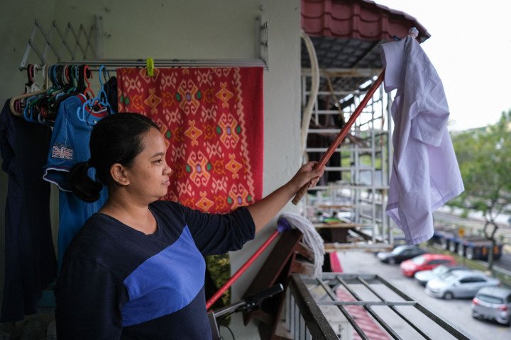 Seorang ibu tunggal Tilda Kalaivani melambaikan kemeja untuk digunakan sebagai bendera putih untuk meminta bantuan, setelah terkena pandemi virus korona (Covid-19), di apartemen sewaannya di Kuala Lumpur.