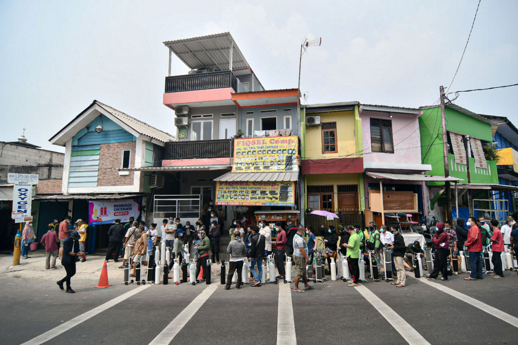 Sejumlah warga mengantre untuk mengisi ulang oksigen medis yang dibagikan secara gratis di kawasan Manggarai, Jakarta.