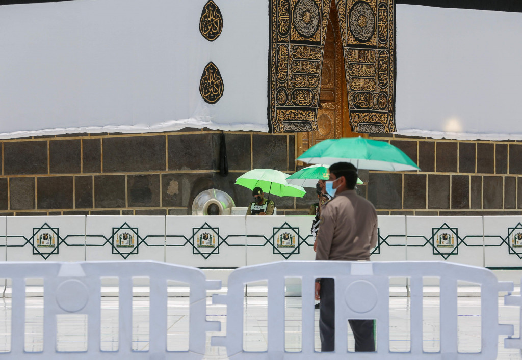Anggota pasukan keamanan Saudi dan staf berjaga-jaga di sekitar Ka'bah, tempat suci umat Islam, di Masjidil Haram, Kota Suci Mekkah, pada 16 Juli 2021, menjelang dimulainya musim haji 2021.