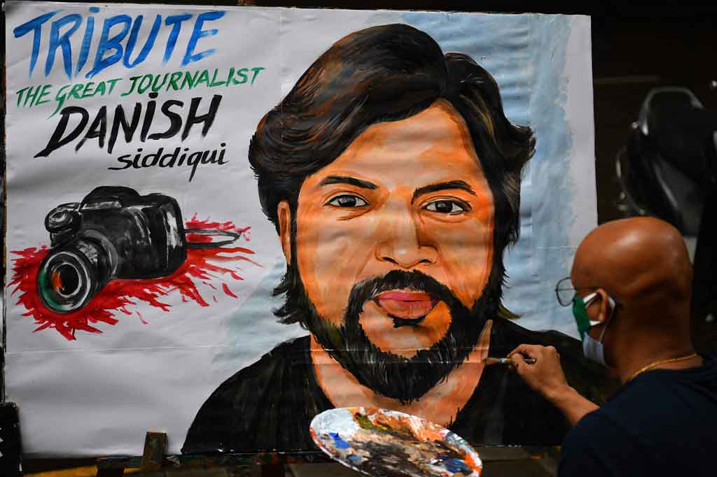 Seorang guru seni memberikan sentuhan akhir pada lukisan jurnalis Reuters Danish Siddiqui sebagai penghormatan terakhir, di luar sebuah sekolah seni di Mumbai, India pada Jumat, 16 Juli 2021.