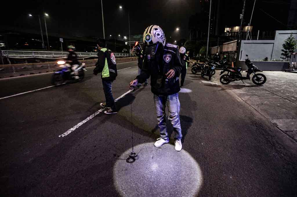 Relawan dari Team Berantas Ranjau melakukan penyisiran di Jalan Gatot Subroto, Jakarta Sabtu, 17 Juli 2021 dini hari WIB, untuk menyapu keberadaan ranjau paku yang bertebaran di jalan.