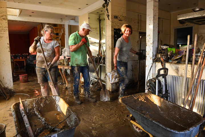 Warga kembali dari pengungsian untuk membuang genangan air serta membersihkan tumpukan lumpur di rumah mereka.