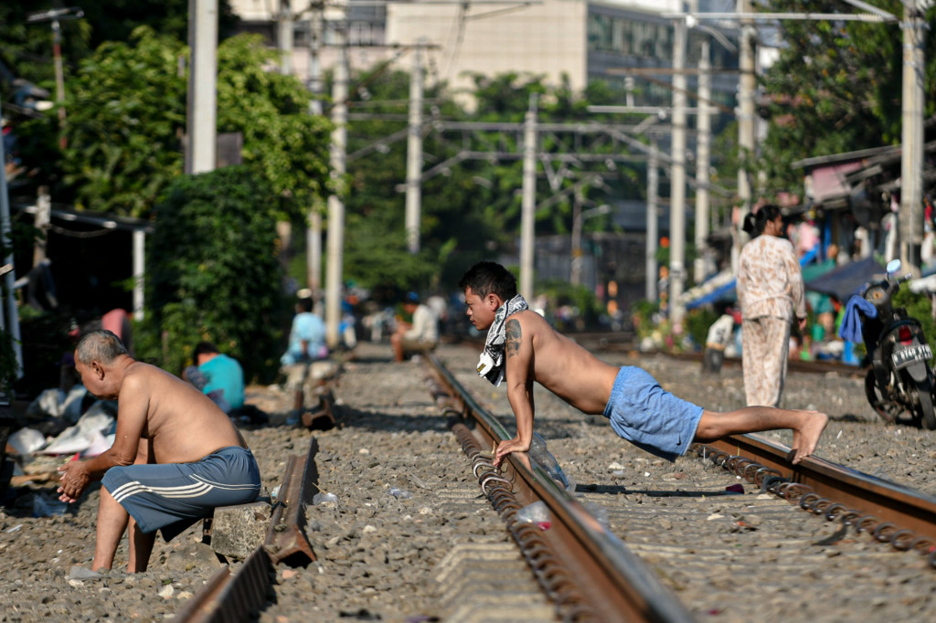 Warga yang tinggal di kawasan permukiman padat bantaran rel kereta api tersebut berusaha untuk tetap menjaga imunitas tubuh dengan berjemur dan berolahraga ringan.