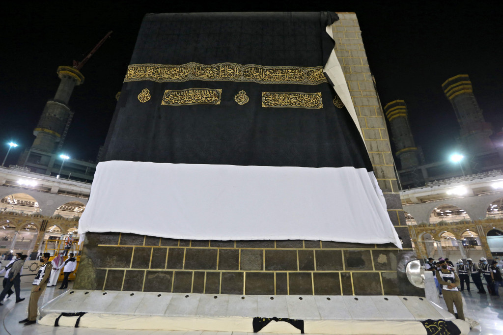 Petugas mengganti kain penutup Ka'bah (kiswah) pada musim haji 2021 di kota suci Mekah, Arab Saudi, 18 Juli 2021, malam.