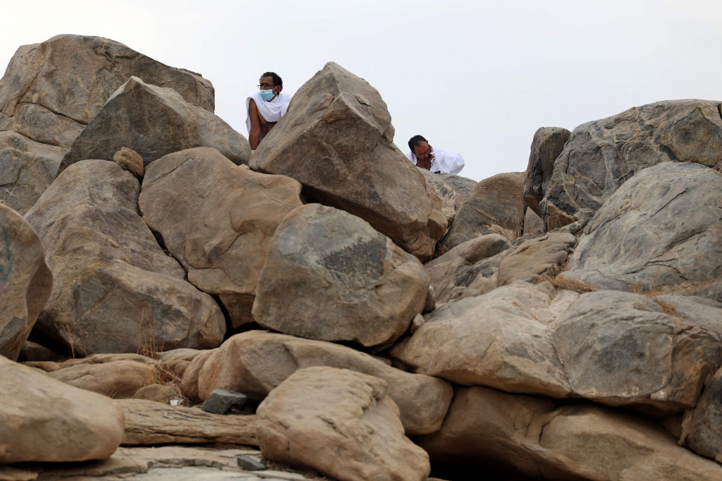 Para jemaah haji berjalan menuju bukit batu saat akan menunaikan puncak ibadah haji, wukuf di Arafah.