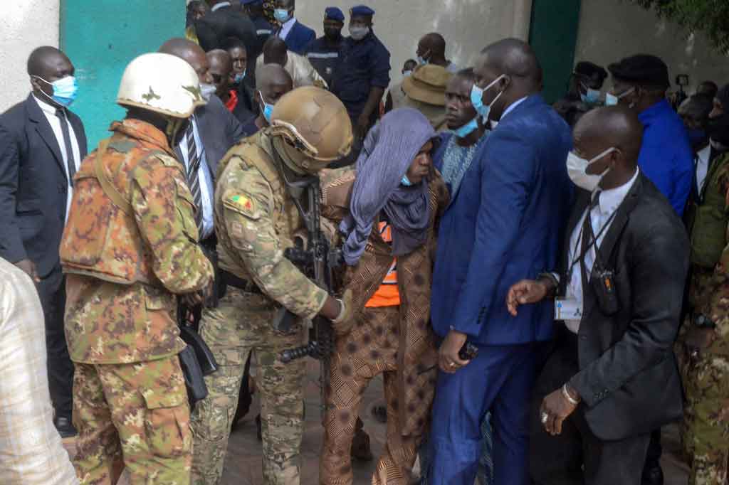 Personel keamanan meringkus seorang terduga pelaku (tengah) dari Masjid Agung Fayçal di Bamako pada Selasa, 20 Juli 2021 waktu setempat, setelah dua penyerang berusaha menikam Presiden sementara Mali Kolonel Assimi Goita selama Salat Idul Adha.