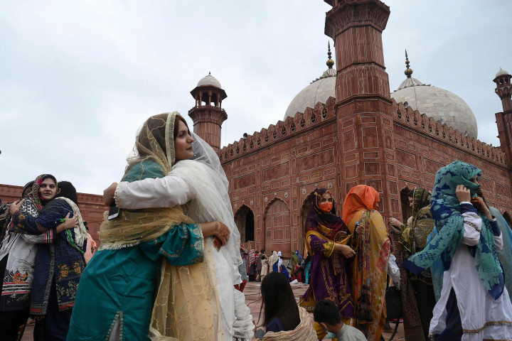 Umat muslim saling berpelukan usai melaksanakan salat Idul Fitri di Masjid bersejarah Badshahi saat Idul Adha atau 'Festival Kurban, di Lahore pada 21 Juli 2021. AFP Photo/Arif Ali