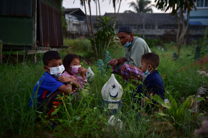 Peziarah mendoakan orang tua dan sanak keluarganya yang telah meninggal ketika berziarah di pemakaman di provinsi selatan Thailand Narathiwat pada 21 Juli 2021. AFP Photo/Madaree Tohlala