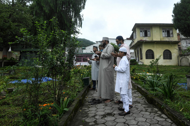 Umat ??muslim berdoa di sebelah makam kerabat mereka di pemakaman selama Idul Adha atau 'Festival Kurban, di Kathmandu pada 21 Juli 2021. AFP Photo/Prakash Mathema