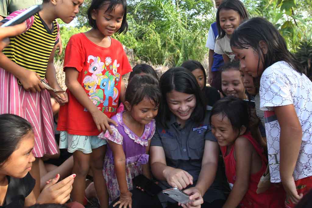 Anak-anak bersama tim Ekspedisi Bakti Untuk Negeri menjelajah internet di atas Bukit Sejuang atau warga setempat menyebut bukit sinyal di Desa Tebuah Elok, Kecamatan Subah, Kabupaten Sambas, Kalimantan Barat, Jumat, 23 Juli 2021.
