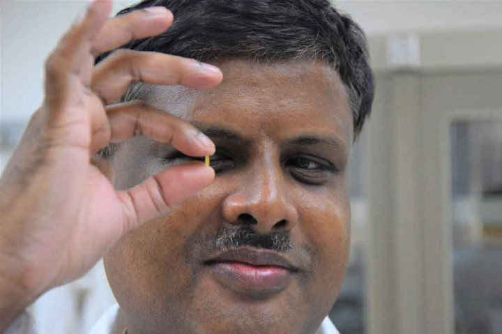 Breeder 'padi emas' Mallikarjuna Swamy memegang sebutir beras emas di organisasi penelitian dan pelatihan pertanian internasional (International Rice Research Institute/IRRI) di Los Banos, Provinsi Laguna, selatan Manila.