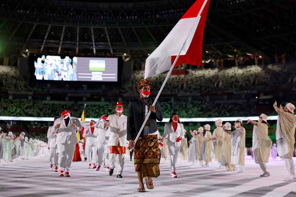 Atlet surfing Rio Waida menjadi pembawa bendera Merah Putih dalam parade defile Olimpiade dengan mengenakan pakaian adat Bali, Payas Madya, didampingi Chef de Mission Olimpiade Rosan P Roeslani yang tampil berbalut busana adat betawi dan lifter putri Nurul Akmal.