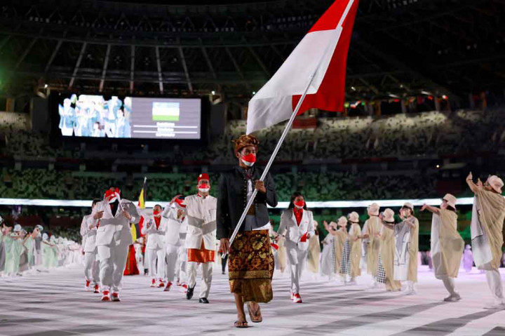 Atlet surfing Rio Waida menjadi pembawa bendera Merah Putih dalam parade defile Olimpiade dengan mengenakan pakaian adat Bali, Payas Madya, didampingi Chef de Mission Olimpiade Rosan P Roeslani yang tampil berbalut busana adat betawi dan lifter putri Nurul Akmal.