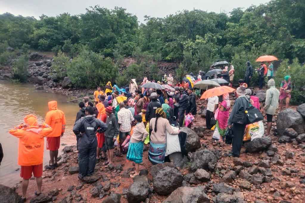 Personel Pasukan Tanggap Bencana Nasional (NDRF) menunggu perahu penyelamat bersama warga korban banjir setelah hujan deras mengguyur wilayah Ambewadi, Distrik Kolhapur, Maharastra.