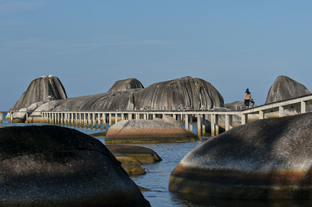 Warga saat berwisata di kawasan Pantai Tapak Natuna, Natuna, Kepulauan Riau, Minggu, 25 Juli 2021. 