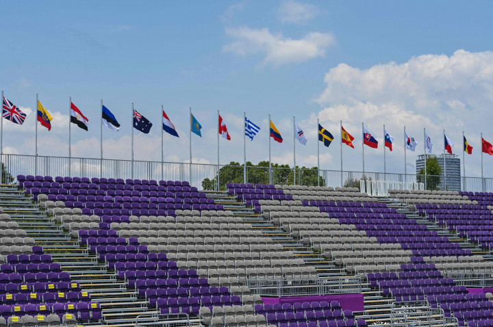 Bendera nasional menghiasi tempat duduk penonton yang kosong di tim eliminasi campuran selama Olimpiade Tokyo 2020 di Lapangan Panahan Taman Yumenoshima di Tokyo.
