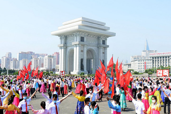 Ratusan siswa memakai masker dan baju adat saat ikut serta dalam 'pesta dansa' di luar Grand Theatre, Pyongyang, Korea Utara. 