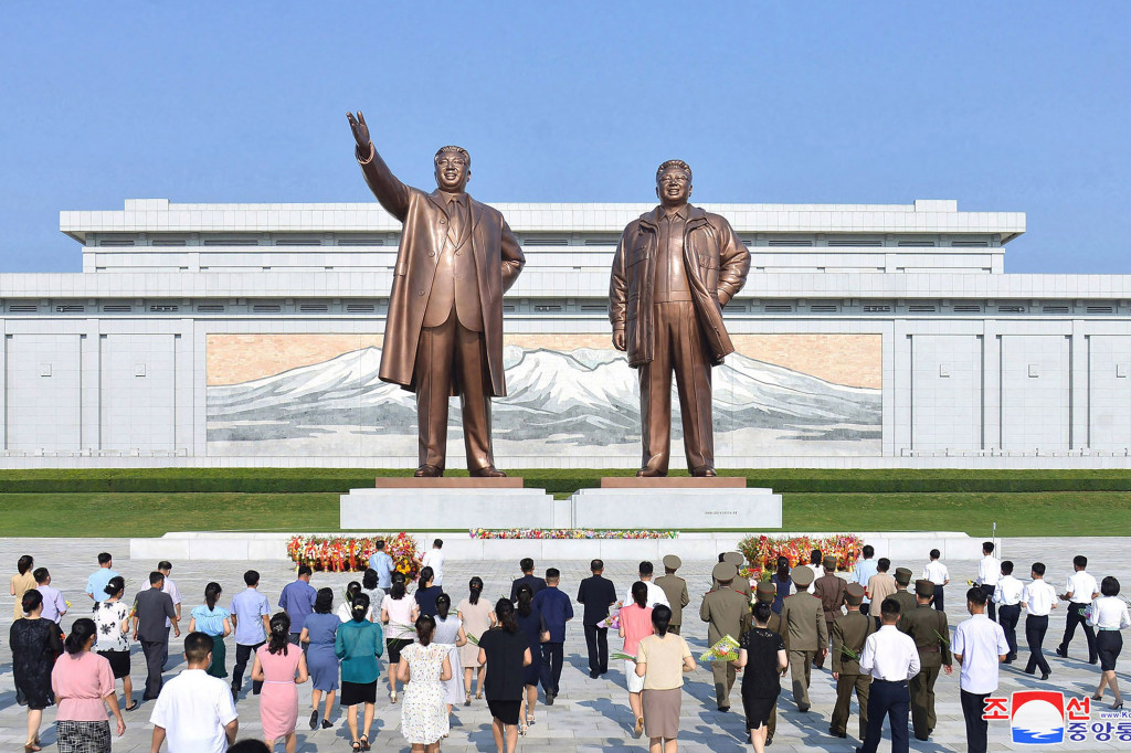 Orang-orang terlihat berbondong-bondong mendaki Bukit Mansu di pusat kota Pyongyang untuk meletakkan bunga, dan membungkuk di hadapan patung raksasa kedua Kim.