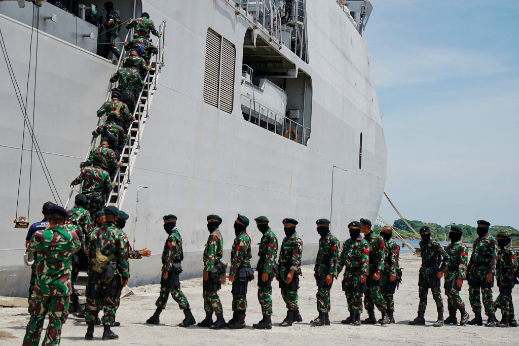 Prajurit Raider TNI antre menaiki tangga kapal TNI Angkatan Laut saat akan diberangkatkan dari Pelabuhan Umum Krung Geukuh, Aceh Utara, Aceh.