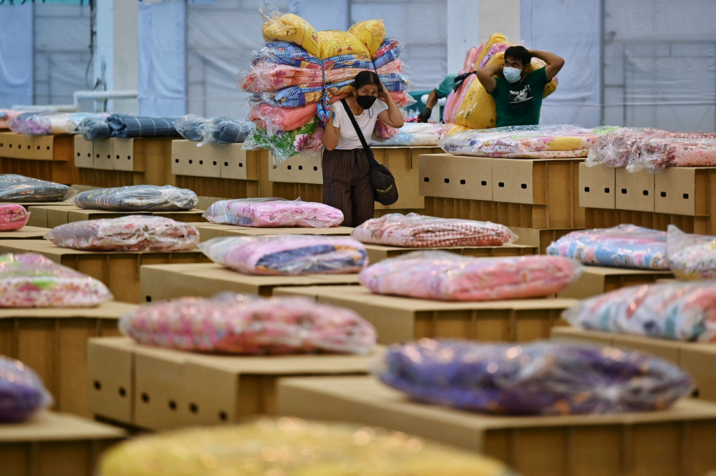 Tampak para relawan tengah mempersiapkan tempat tidur untuk RS darurat ini.