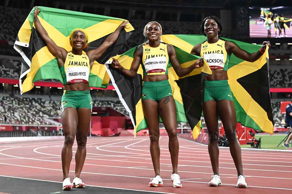 Pemenang lari 100 meter putri, Elaine Thompson-Herah (tengah) berpose dengan peringkat kedua Shelly-Ann Fraser-Pryce (kiri) dan peringkat ketiga Shericka Jackson (kanan) setelah final 100m putri Olimpiade Tokyo 2020 di Stadion Olimpiade di Tokyo pada Sabtu, 31 Juli 2021.