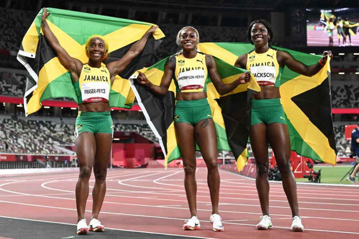 Pemenang lari 100 meter putri, Elaine Thompson-Herah (tengah) berpose dengan peringkat kedua Shelly-Ann Fraser-Pryce (kiri) dan peringkat ketiga Shericka Jackson (kanan) setelah final 100m putri Olimpiade Tokyo 2020 di Stadion Olimpiade di Tokyo pada Sabtu, 31 Juli 2021.