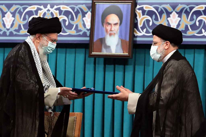 Kepala staf (kiri) menyerahkan dekrit dari pemimpin tertinggi Iran Ayatollah Ali Khamenei kepada Ebrahim Raisi selama pelantikannya menjadi Presiden, di kantor Khamenei, Teheran, Selasa, 3 Agustus 2021.