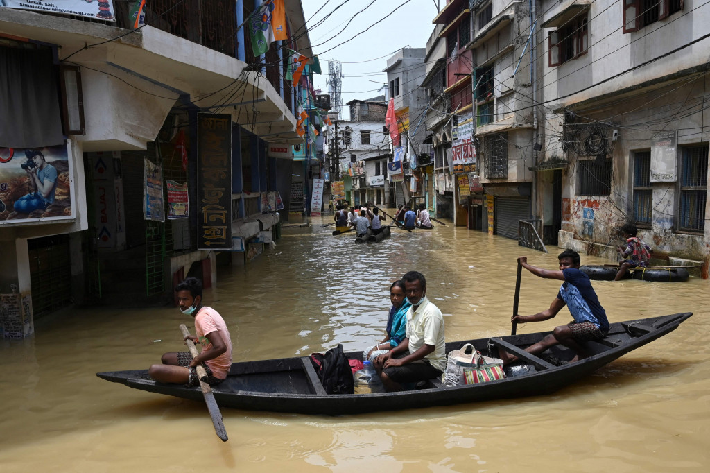 Warga menaiki perahu di atas jalan yang terendam banjir menyusul hujan lebat di Ghatal, distrik Paschim Medinipur, sekitar 100 km dari Kolkata.
