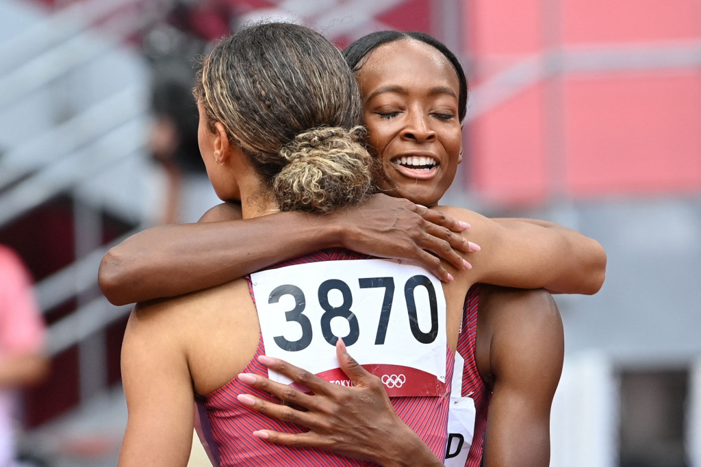 Pelari Amerika Serikat, Sydney McLaughlin (kanan), mendapat pelukan dan ucapan selamat dari rekan satu negaranya, Dalilah Muhammad, setelah finis pertama dan memecahkan rekor dunia dan Olimpiade pada final lari gawang 400 meter putri Olimpiade Tokyo 2020 di Stadion Olimpiade, Tokyo, Jepang.