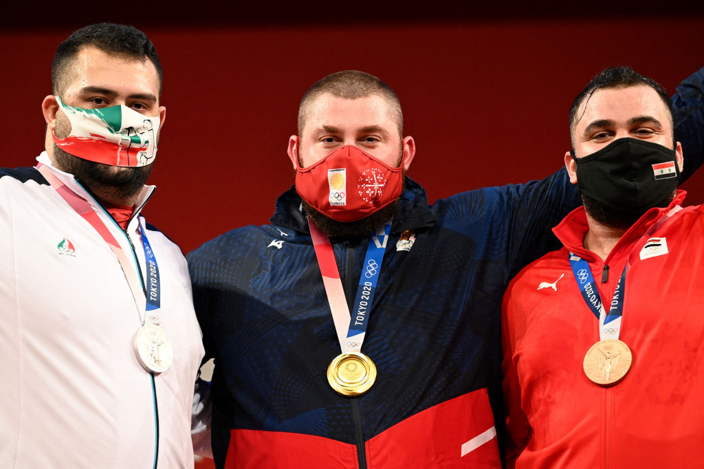 Sementara itu lifter Iran, Ali Davoudi (kiri), mengamankan medali perak. Davoudi mencatatkan 200kg pada sesi snatch, 241 pada sesi clean & jerk, dengan total angkatan 441kg.