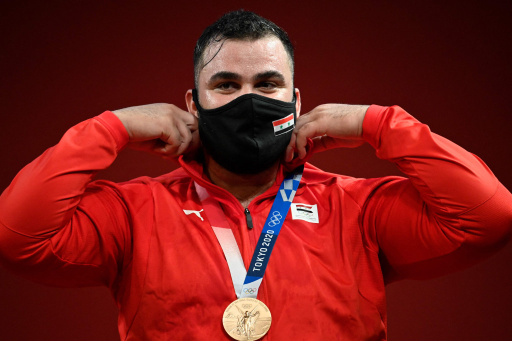 Lalu medali perunggu diraih lifter Suriah, Man Asaad. Asaad mengangkat 190kg pada sesi snatch, 234kg pada sesi clean & jerk, dan 424kg total beban.