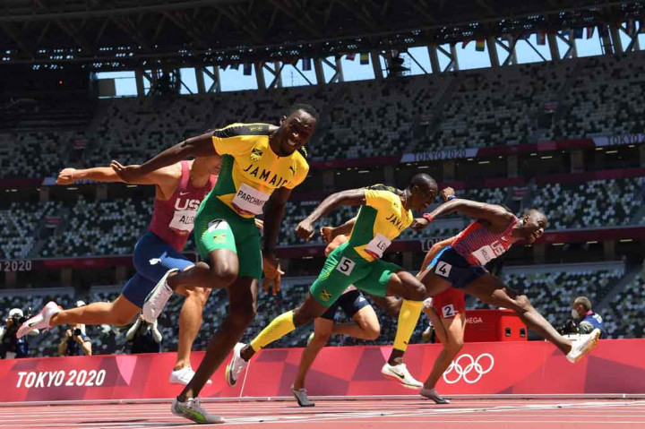 Hansle Parchment (kiri) dari Jamaika melintasi garis finis pertama dalam final lari gawang 110m putra Olimpiade Tokyo 2020 di Stadion Olimpiade, Tokyo pada Kamis, 5 Agustus 2021.
