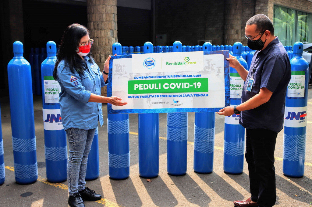 Co Founder BenihBaik.com Anggit Hernowo (kiri) secara simbolis menyerahkan bantuan dari Frisian Flag kepada Perwakilan Dompet Kemanusiaan Media Group (DKMG) Firdaus Dayat, di kompleks Media Group, Jakarta.