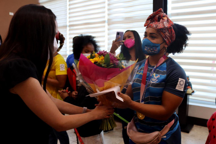 Lifter peraih medali emas Neisi Patricia Dajomes Barrera menerima karangan bunga dari Kementerian Olahraga Ekuador setibanya di bandara Mariscal Sucre Quito, Rabu, 4 Agustus 2021.