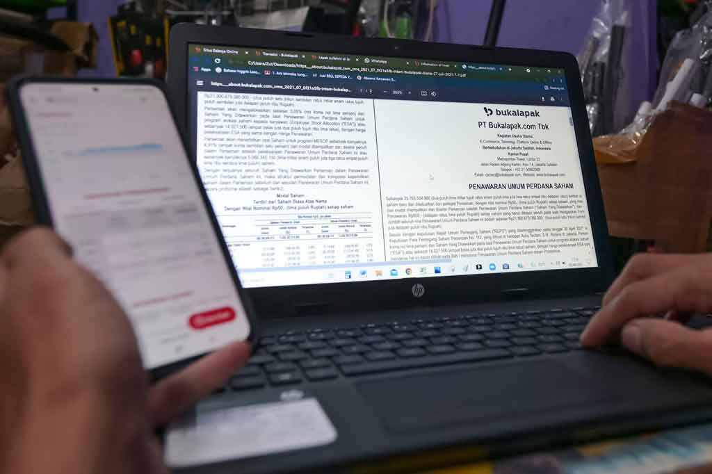 Seorang pedagang suku cadang yang memperdagangkan barang dagangannya secara online di perusahaan e-commerce Indonesia Bukalapak, menelusuri informasi tentang penawaran umum perdana (IPO) perusahaan di laptopnya di Jakarta, menjelang listing Bukalapak di Bursa Efek Indonesia, Jumat, 6 Agustus 2021.