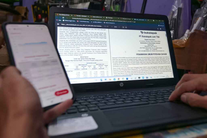 Seorang pedagang suku cadang yang memperdagangkan barang dagangannya secara online di perusahaan e-commerce Indonesia Bukalapak, menelusuri informasi tentang penawaran umum perdana (IPO) perusahaan di laptopnya di Jakarta, menjelang listing Bukalapak di Bursa Efek Indonesia, Jumat, 6 Agustus 2021.