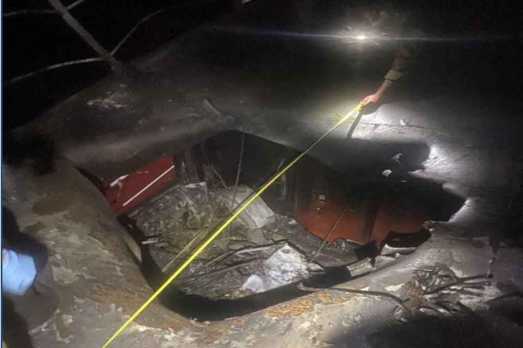 Anak buah kapal tengah mengukur lebar lubang yang ditimbulkan akibat serangan terhadap kapal tanker MT Mercer Street.