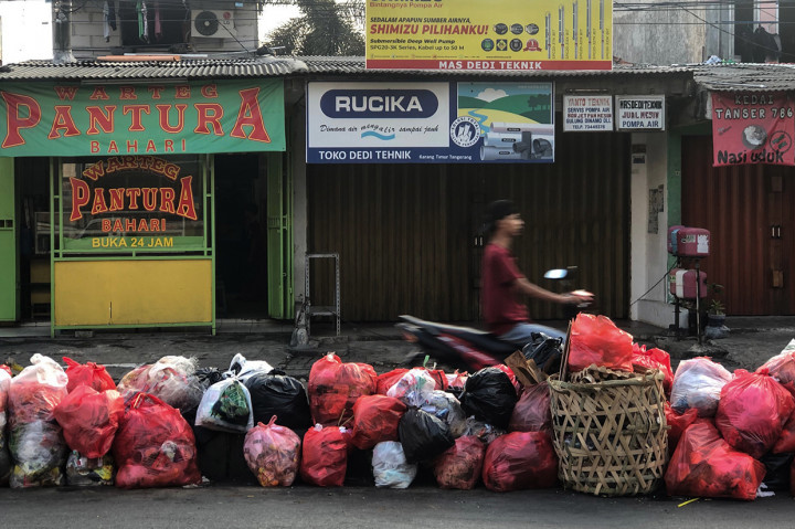 Tumpukan sampah yang dibuang warga memenuhi pembatas jalan di kawasan Ciledug, Tangerang, Minggu, 8 Agustus 2021. 
