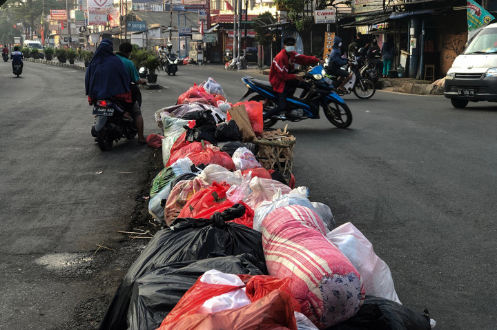 Tumpukan sampah yang dibuang warga memenuhi pembatas jalan di kawasan Ciledug, Tangerang, Minggu, 8 Agustus 2021.