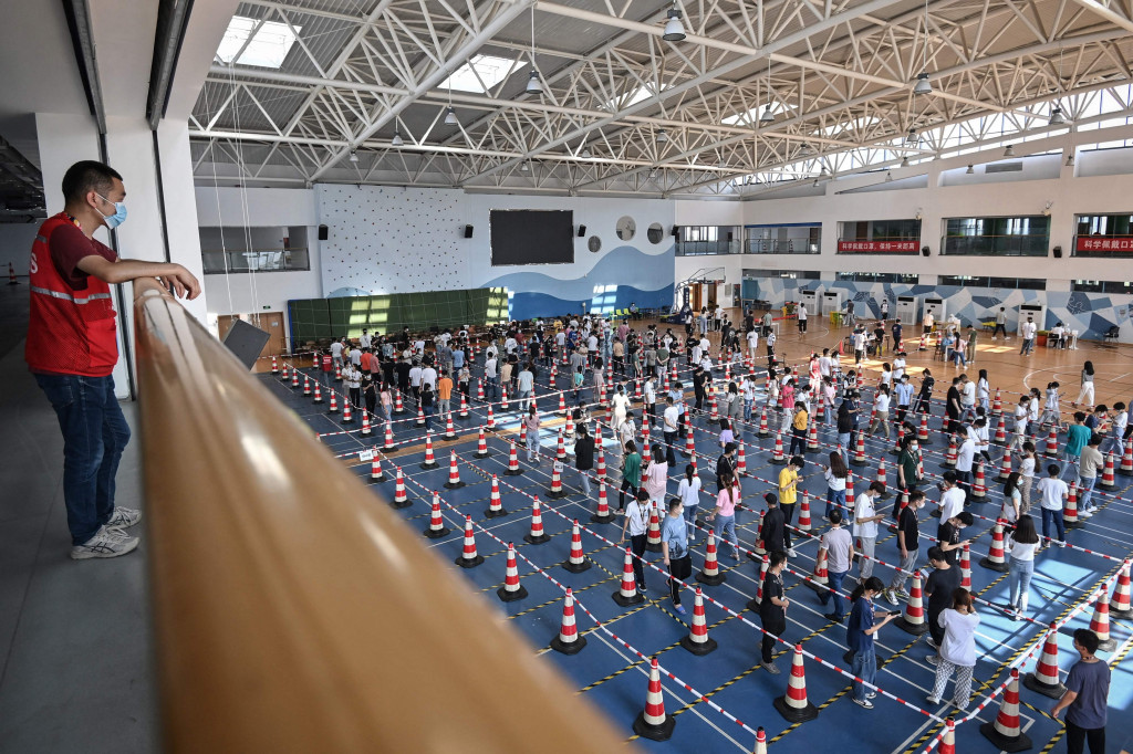 Foto ini diambil pada 5 Agustus 2021 menunjukkan staf mengantre untuk menguji virus korona di gym sebuah perusahaan di Wuhan, provinsi Hubei.