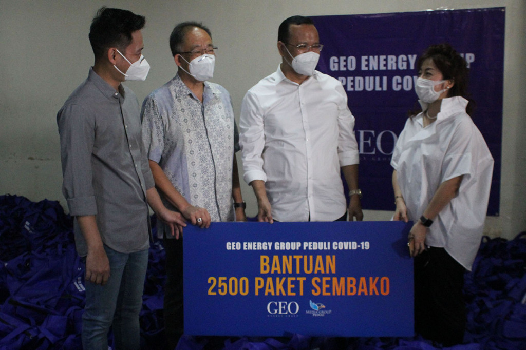 Corporate HR Manager GEO Energy Group Indonesia, Suasa E. Ginting (kedua dari kanan) menyerahkan secara simbolis bantuan paket sembako untuk masyarakat kecil yang terdampak pandemi Covid-19 kepada Chief CSR Officer Media Group Lisa Luhur Schad (kanan) di Komplek Media Group, Jakarta, Senin, 9 Agustus 2021.