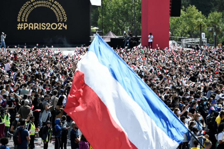 Ribuan warga mengibarkan bendera Prancis dan bersorak untuk menyambut Olimpiade 2024 di Trocadero Gardens, depan Menara Eiffel, Paris, Prancis, Minggu, 8 Agustus 2021.