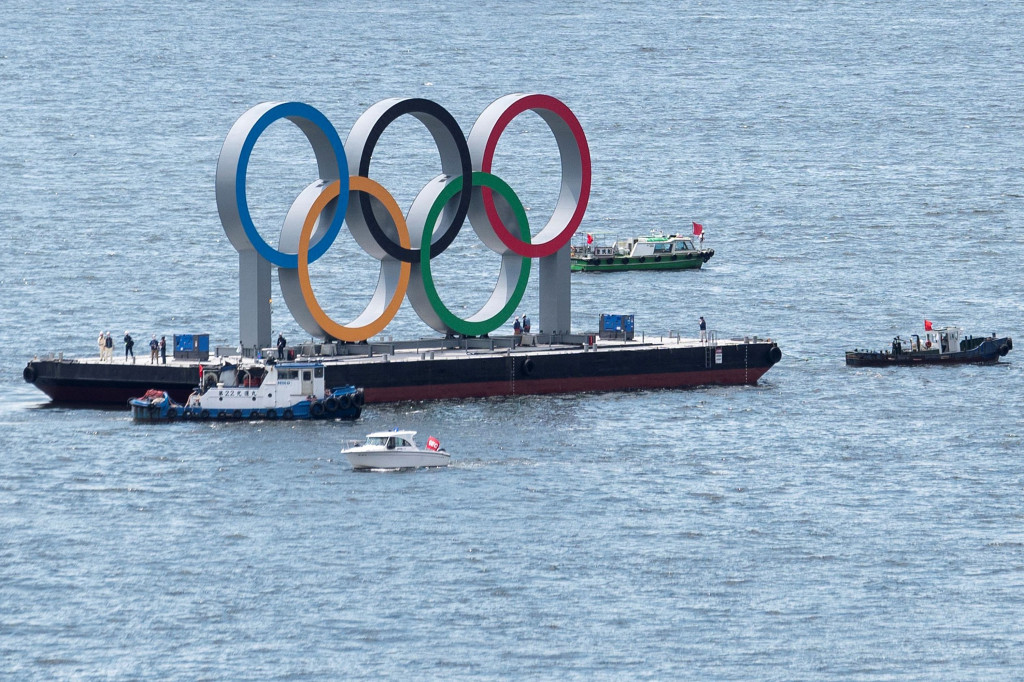 Para pekerja bersiap melepas cincin Olimpiade raksasa yang mengambang di air setelah Olimpiade Musim Panas 2020 berakhir pada 8 Agustus di Tokyo, Rabu, 11 Agustus 2021.