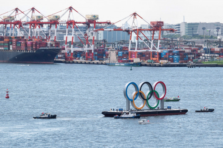 Sebuah perahu menarik cincin Olimpiade raksasa saat dipindahkan dari area tepi laut di Taman laut Odaiba setelah Olimpiade Musim Panas 2020 berakhir pada 8 Agustus di Tokyo, Rabu, 11 Agustus 2021.