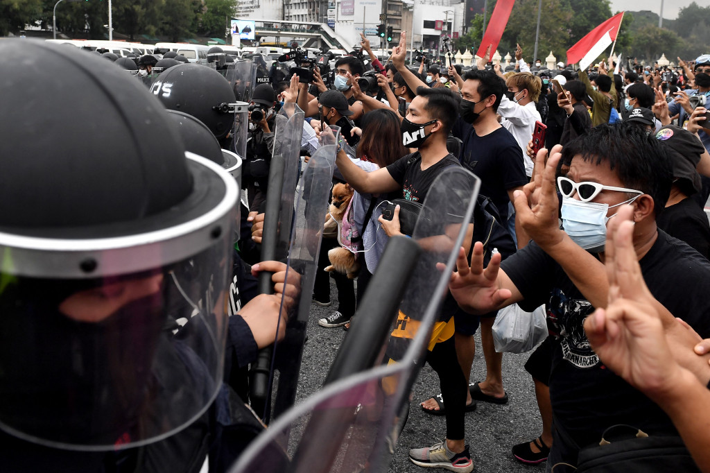 Pengunjuk rasa pro-demokrasi menghadapi polisi anti huru hara selama protes yang menyerukan pengunduran diri perdana menteri Prayut Chan-O-Cha atas penanganan pemerintah Thailand terhadap krisis virus korona dan mengubah undang-undang saat ini, di Bangkok pada 11 Agustus 2021.