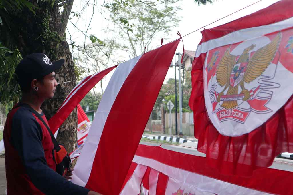 Salah seorang pedagang bendera musiman jelang Agustusan memasarkan dagangannya di Jalan Tentara Jenie Temanggung, Jawa Tengah, Jumat, 13 Agustus 2021.
