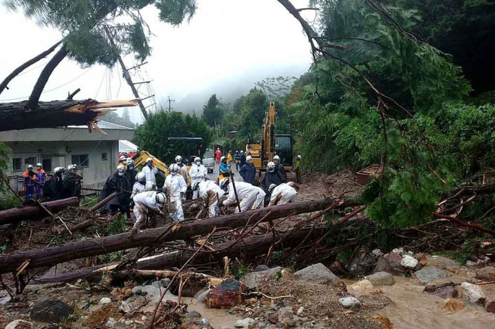 Petugas penyelamat mencari orang hilang di lokasi tanah longsor yang disebabkan oleh hujan lebat di Unzen, Prefektur Nagasaki, Sabtu, 14 Agustus 2021.