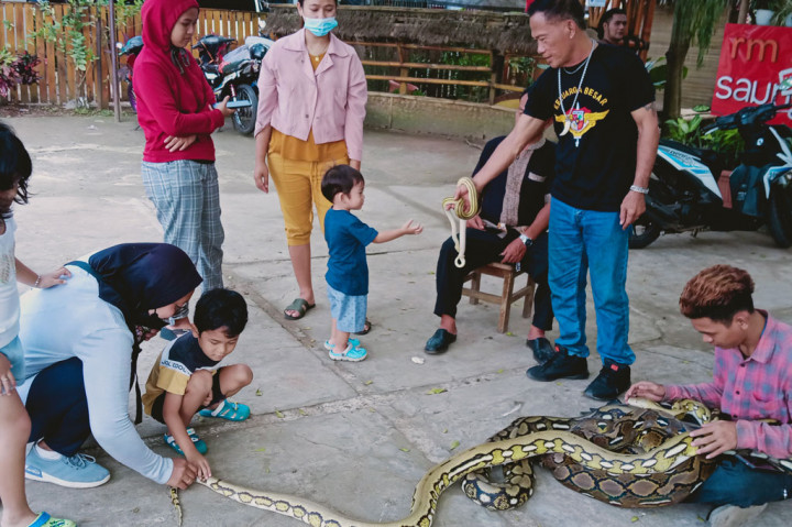 Sekelompok pemuda memamerkan reptil peliharaan mereka di sekitar Setu Pengasinan, Kelurahan Pengasinan, Sawangan, Depok, Jawa Barat. 